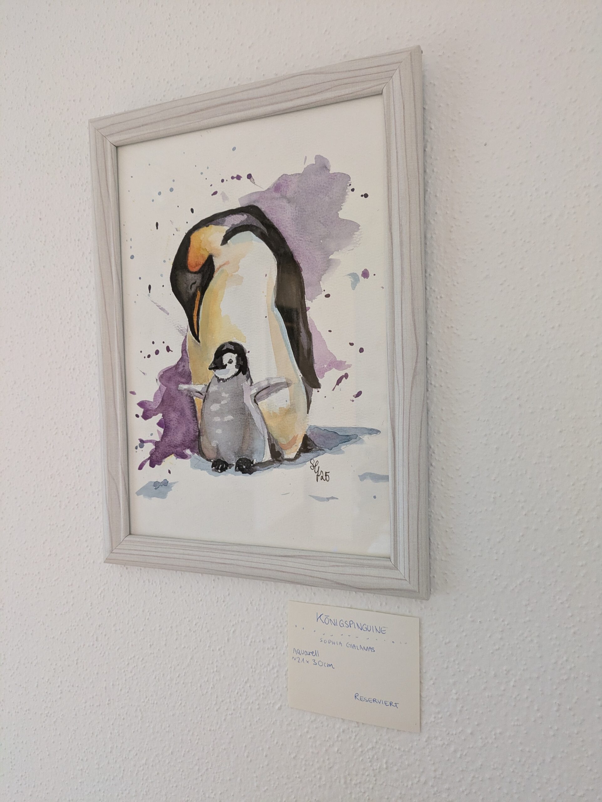 Pinguin mit Baby davor im weißen Rahmen