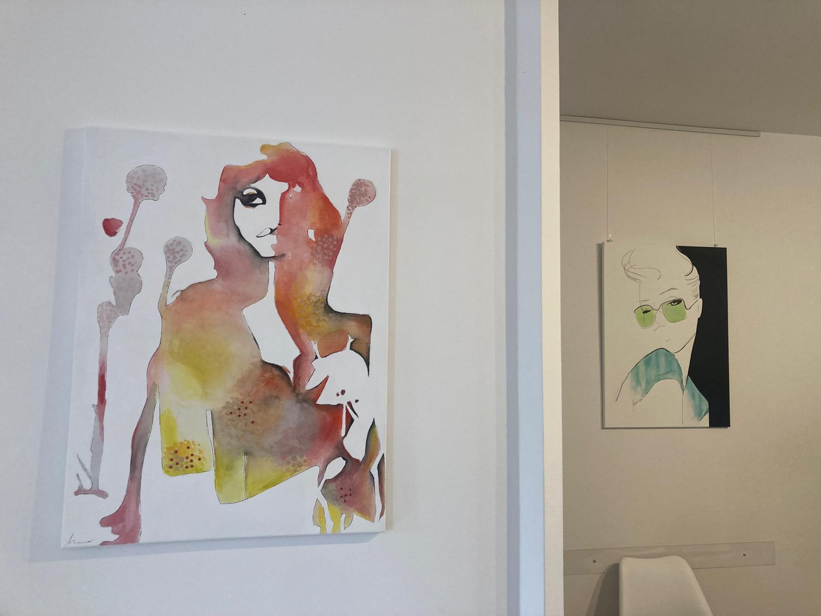 2 Bilder von Frauen bunt gemalt hängend in einem Wartebereich einer Praxis