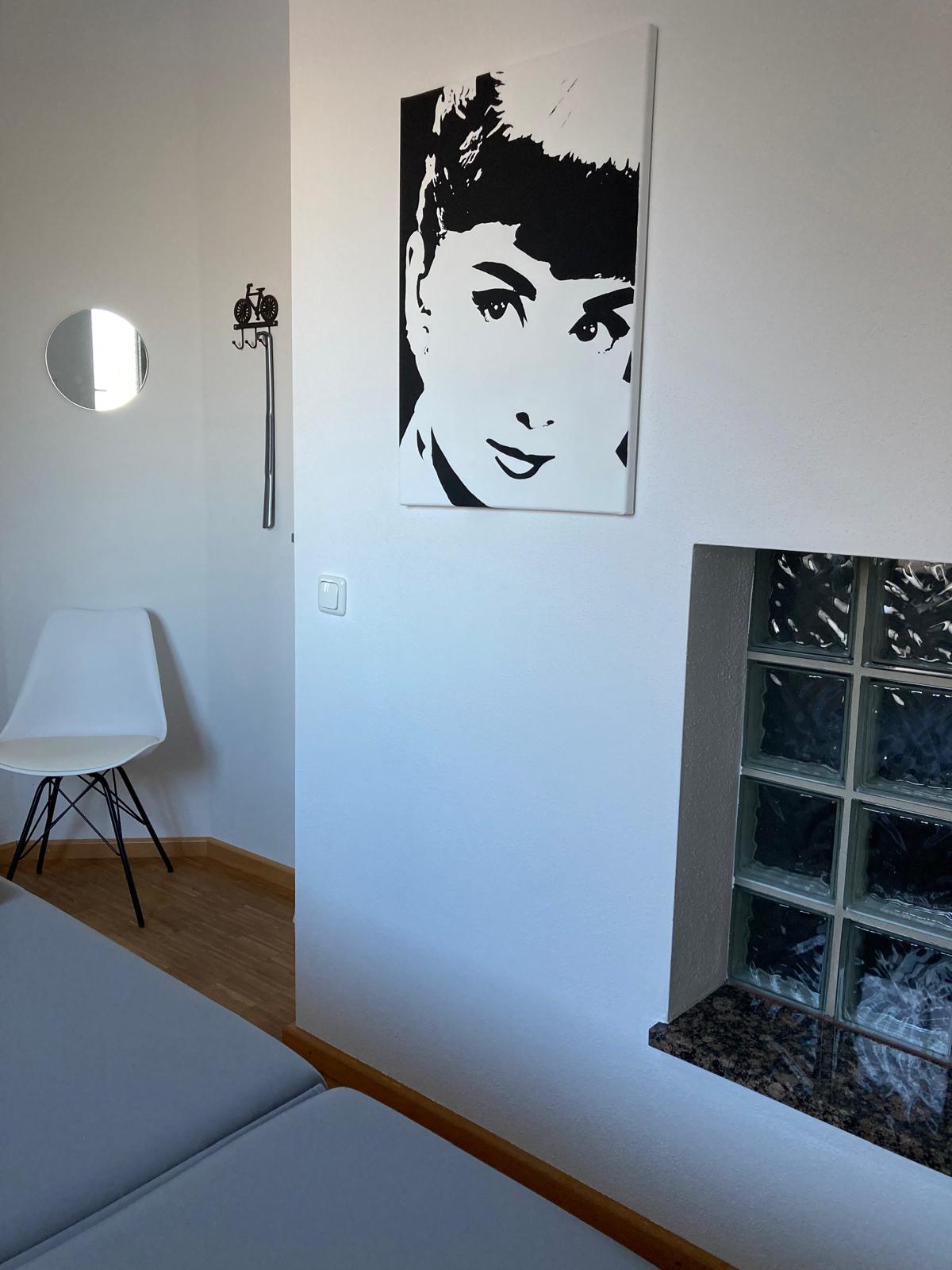 schwarz weiß Portrait einer Frau mit Pony in einem Praxisraum hängend