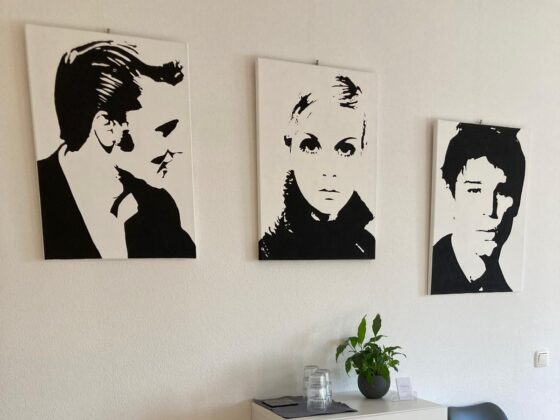 3 schwarz weiß Portraits hängend an der Wand in einem Wartebereich